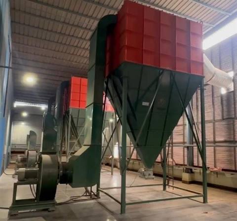 Thermocare dust collector installation in a factory with red filter housing and green hopper